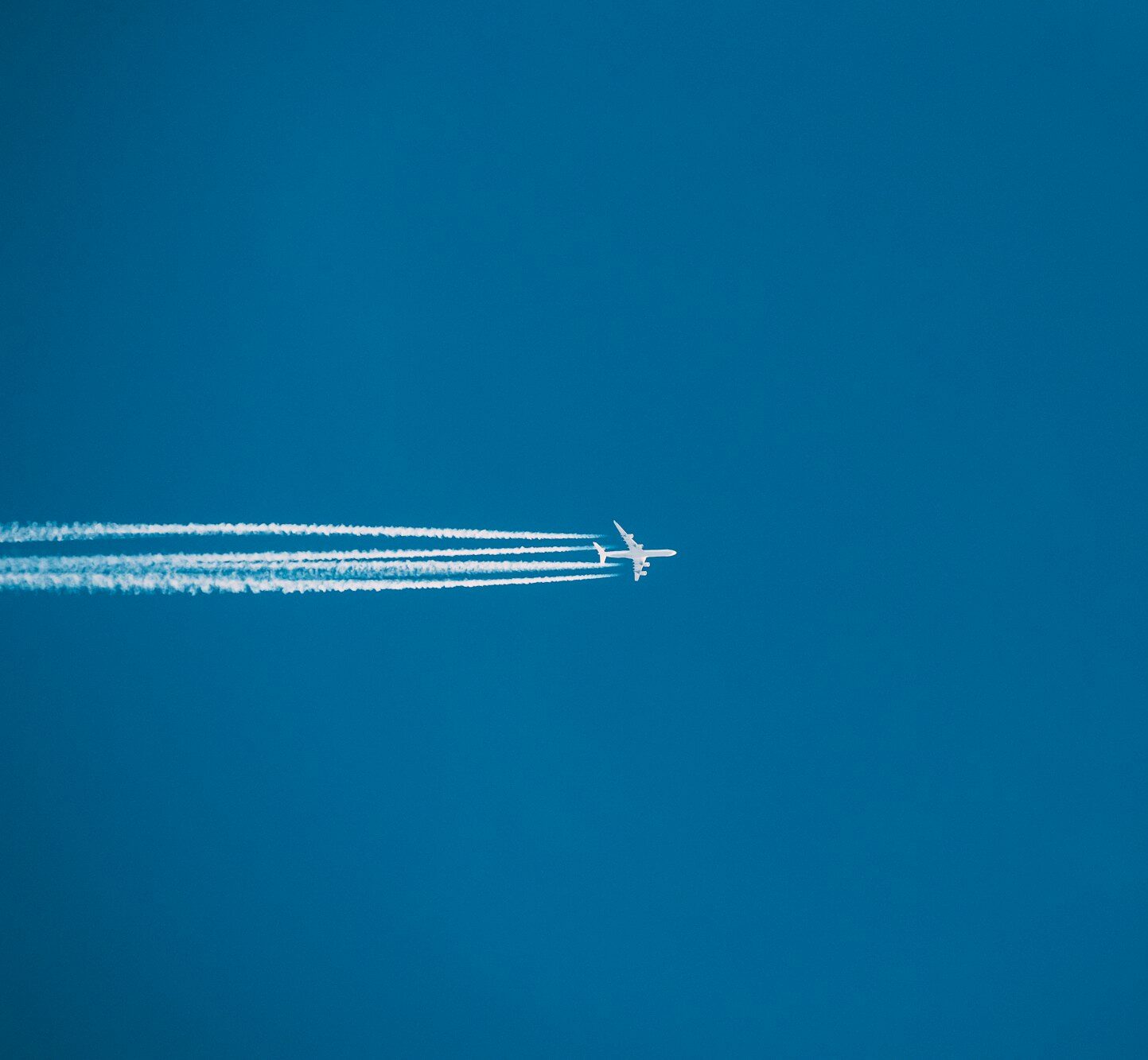 Airplane In The Sky With Plane Trails