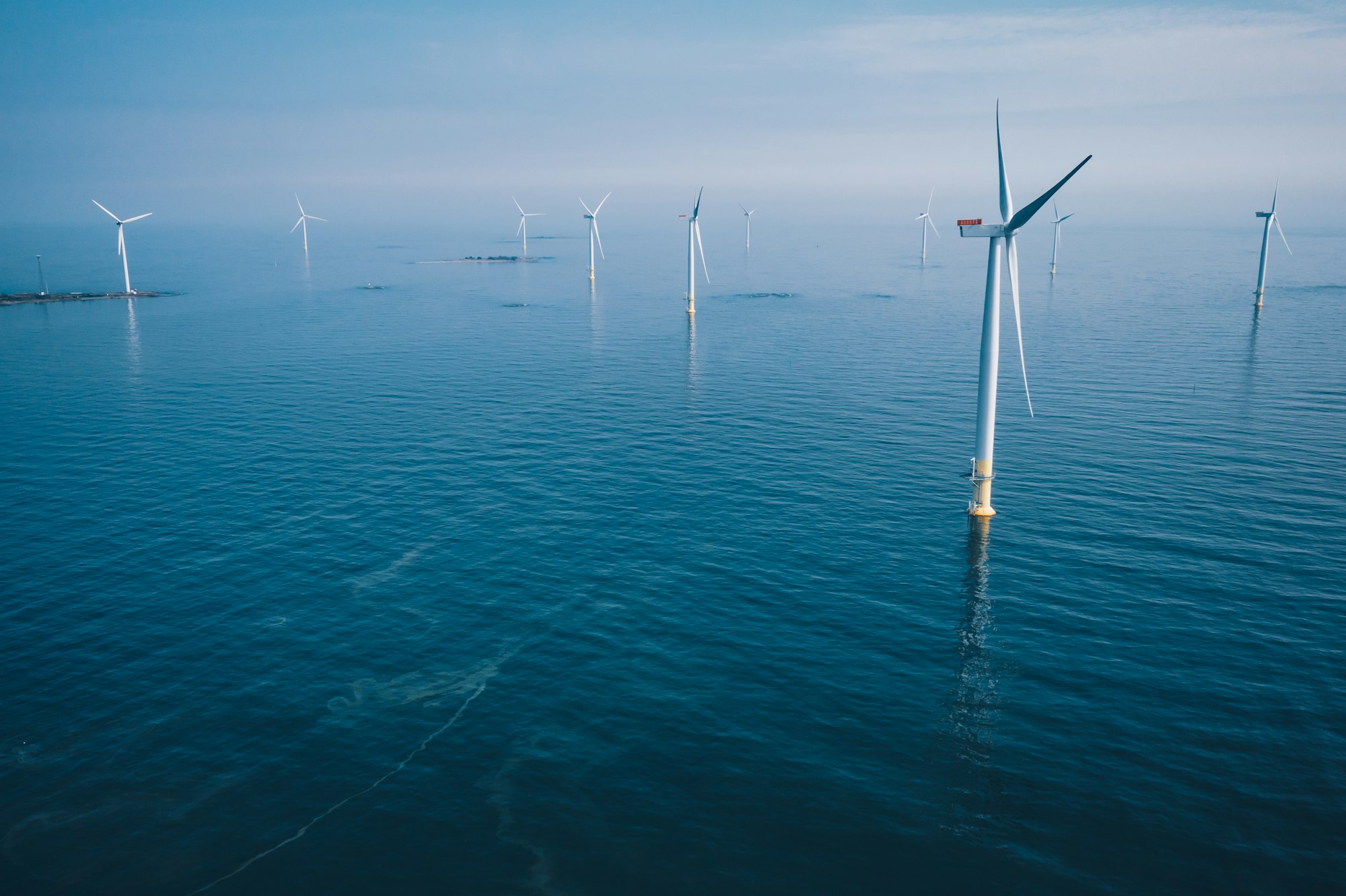 Wind turbine. Aerial view of wind turbines or windmills farm field in blue sea in Finland.